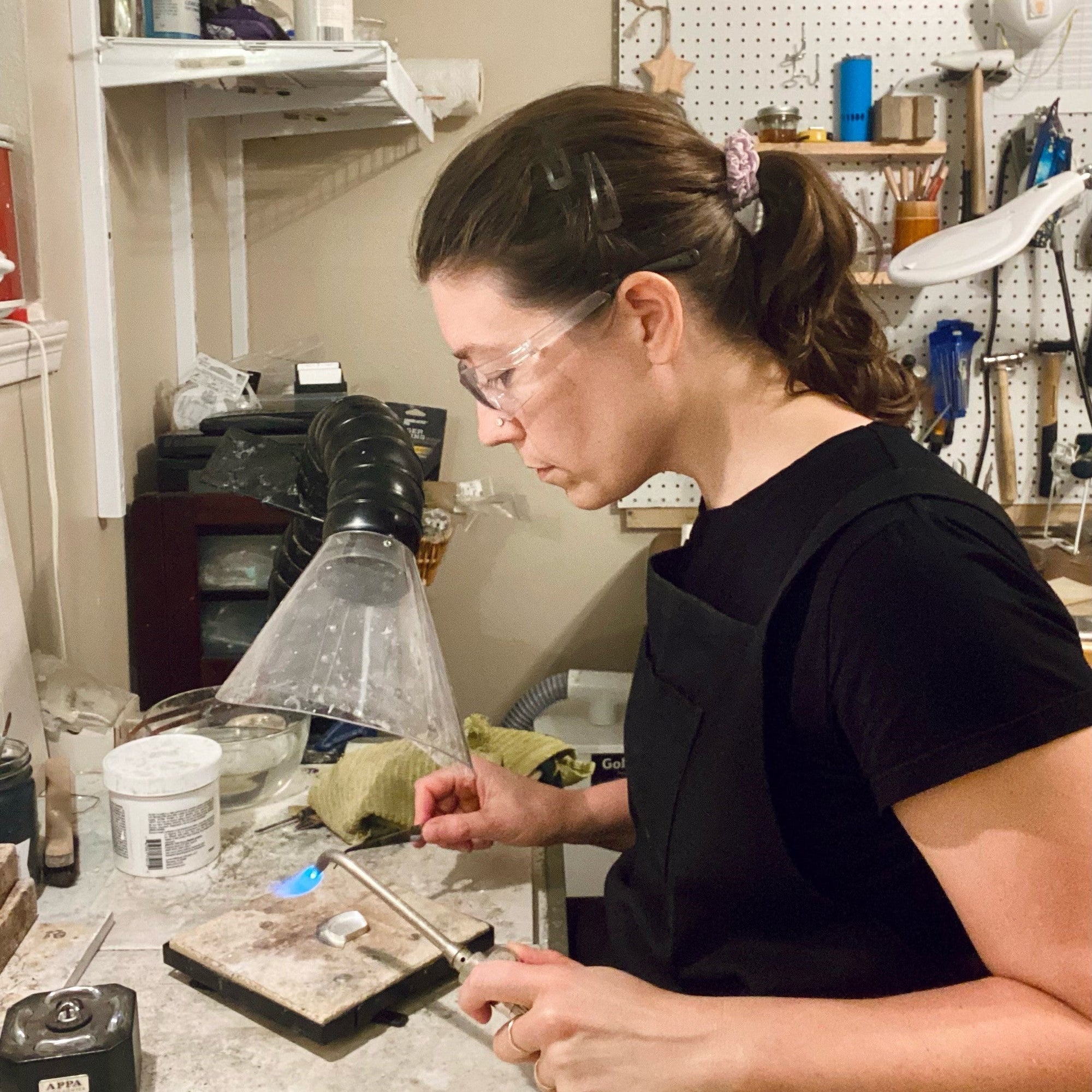 houston, tx jewelry artist, lindsey johnson of geophilia studio working at her jewelry soldering bench