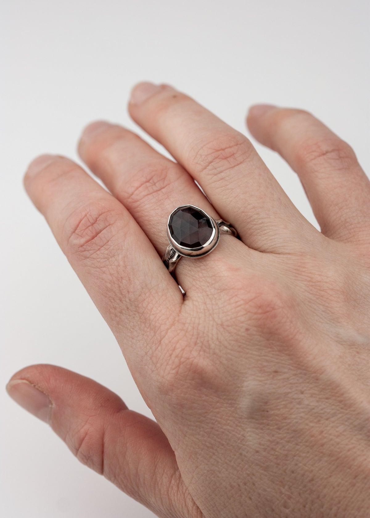 Hand wearing Maroon sapphire ring to show scale