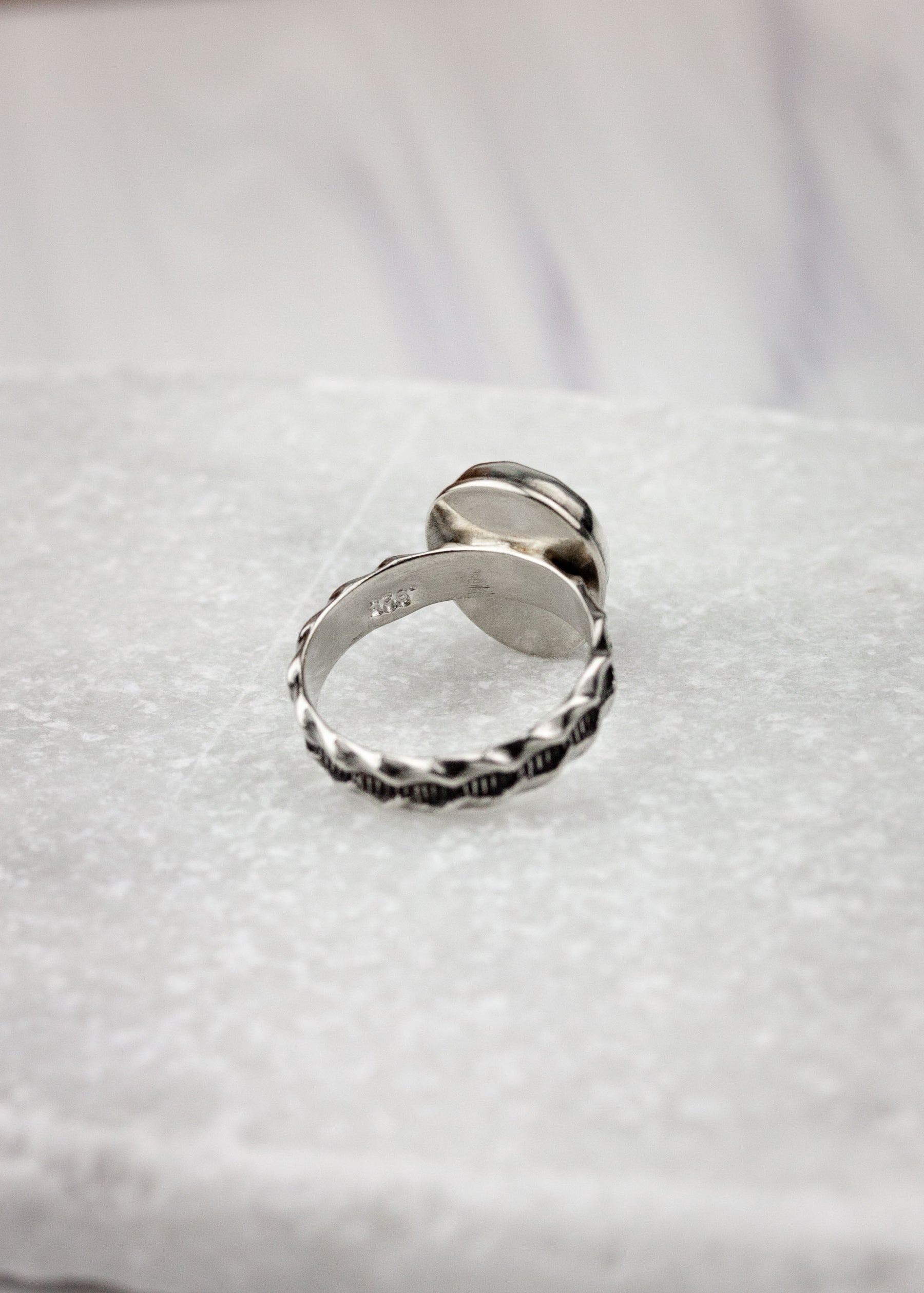 Back of silver ring with purple sapphire