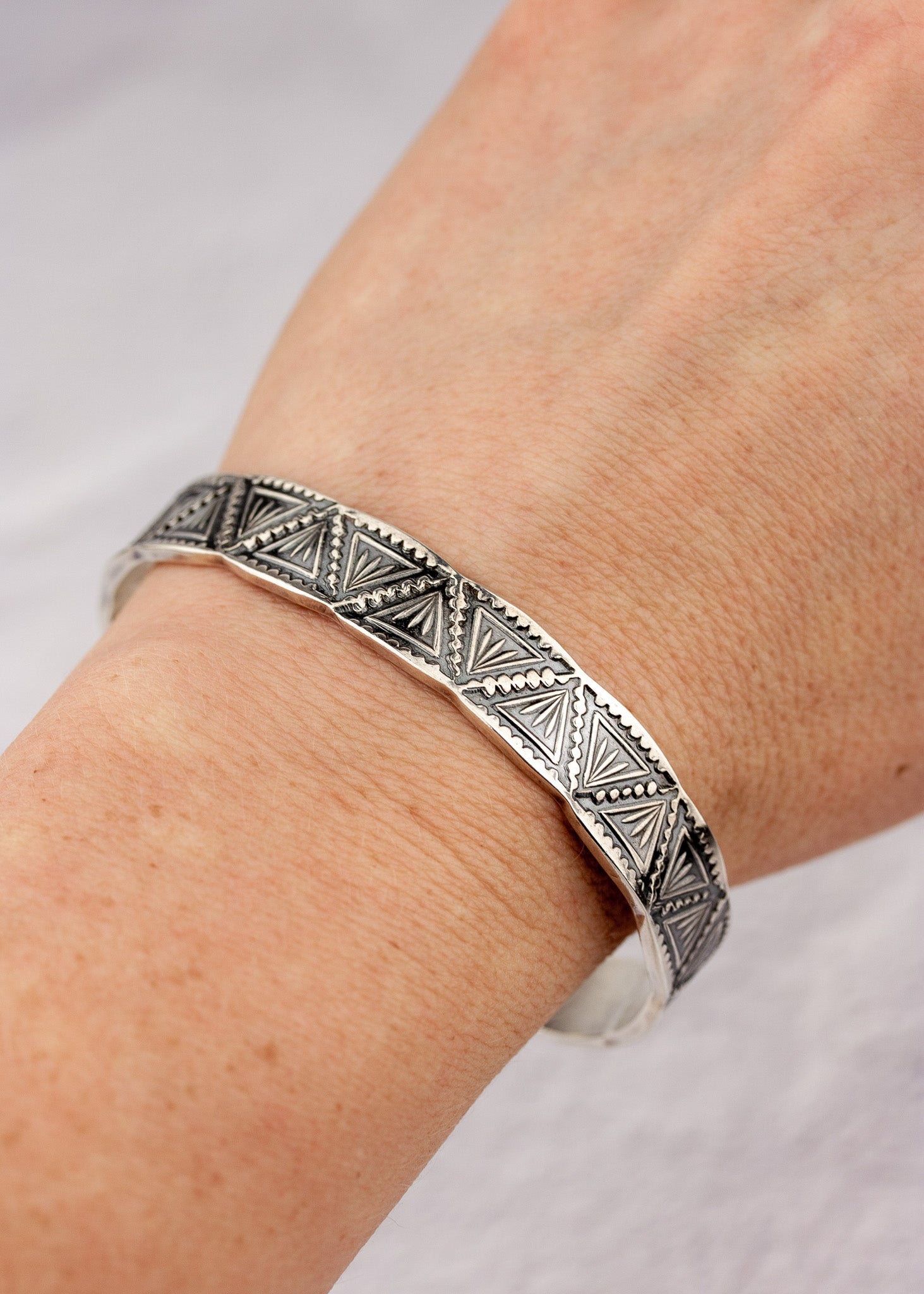 Heavy silver cuff bracelet on an arm