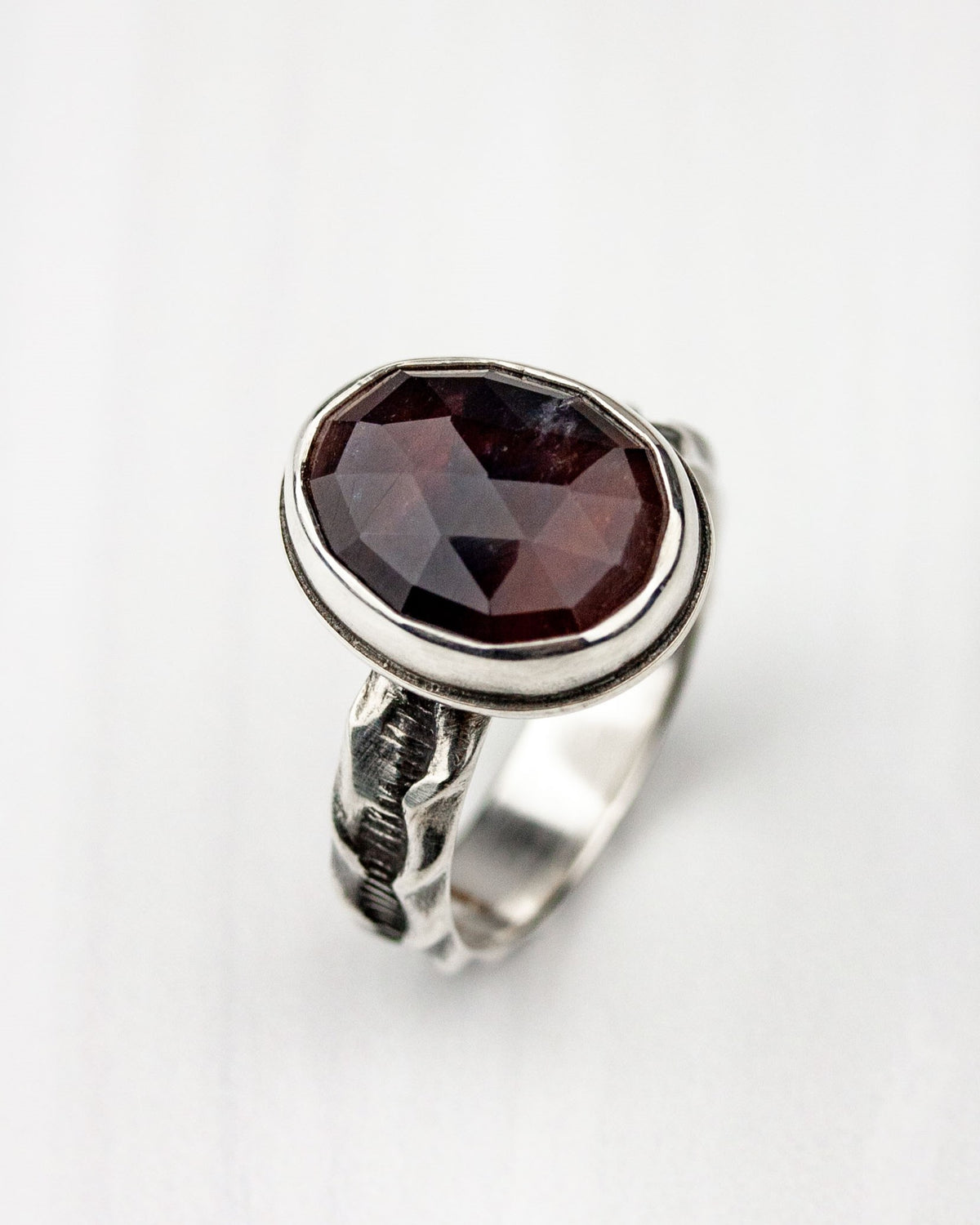 Maroon sapphire ring on white background